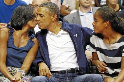 El beso de Obama a su esposa en un partido de baloncesto genera debate