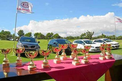 Los trofeos que se repartieron al acabar el torneo con la gama Kia expuesta en el campo de golf.