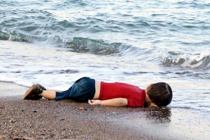 A young migrant, who drowned in a failed attempt to sail to the Greek island of Kos, lies on the shore in the Turkish coastal town of Bodrum