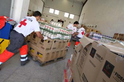 ayuda. Un grupo de voluntarios de Cruz Roja de Alaior prepara los lotes que serán repartidos entre familias necesitadas - Gemma