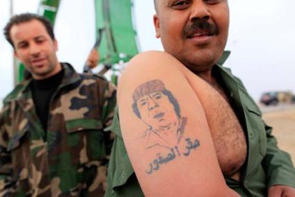 ajdabiyah. Un combatiente de las fuerzas oficiales muestra un tatuaje con la imagen de Gadafi - REUTERS