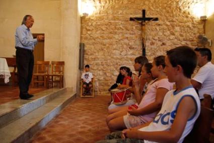 Xerrada. Els fillets i filletes que acudiren a l’ermita, acompanyats pels pares, escoltant a Carlos Torrent - Carles Mascaró