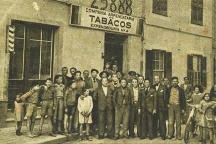 Afortunados. Fotografía cedida por José María Mayans, con algunos premiados ante el estanco en el que fue expedido, en pequeñas participaciones, el billete agraciado