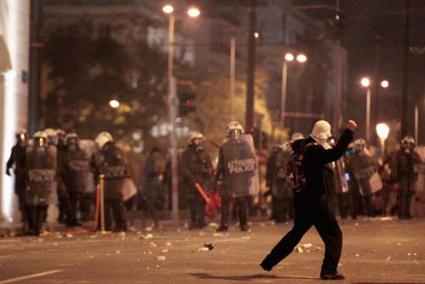 Atenas. Un manifestante lanza piedras a los policías en la céntrica Plaza Sintagma - Reuters