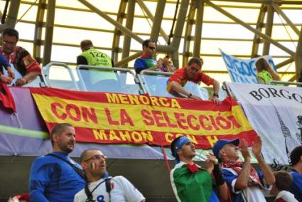 Menorca. Arriba Juan Bravo colocando una bandera española con identificación menorquina en el Estadio de Gdanst, y abajo con un grupo de irlandeses