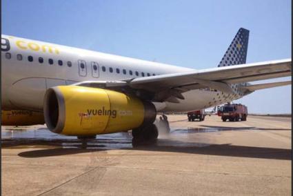 Incidente. Personal de emergencia del Aeropuerto de Menorca refrigera los neumáticos del avión A320 tras sufrir el pinchazo - C.