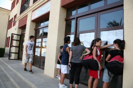 Joan Ramis. Varios estudiantes miran las listas de alumnos colocadas en las puertas del centro - Javier