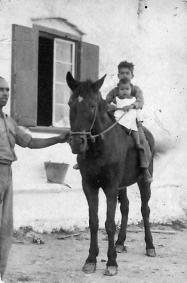 Sínia des Moret (carretera de Villacarlos) Mi padrino de pila, Francisco Cardona Llull, la autora de este trabajo a los catorce meses, sostenida por mi primo, "al cel sia", Pepito Cardona Villalonga, el 10 de octubre de 1945. Foto realizada por Juan Sturla (archivo Margarita Caules)