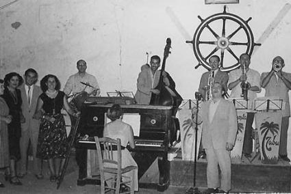 De izquierda a derecha la esposa de Soler, Antonia Previ, Lluís Valls, Juana Fortuny, ¿? Rafael Quintana, José Fortuny, ¿? Mangado, todos ellos con instrumentos acompañando al cantante frente al micro, Paco Soler, y la pianista María, esposa de Quintana. ( Fotografía de Berto Fortuny)