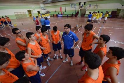 Anglada. El técnico de Ciutadella, con veinte participaciones en el campus, departe con el grupo infantil que ha coordinado este año - Élite Jove