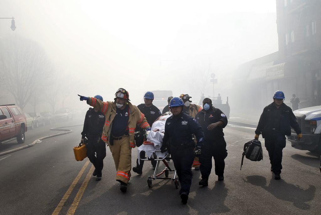 A victim is evacuated by emergency personal near an apparent building explosion fire and collapse in the Harlem section of New Y