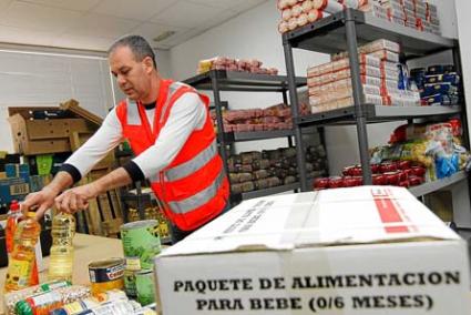 Un voluntario de la Cruz Roja preparando los alimentos ayer en la oficina de Maó - Gemma Andreu