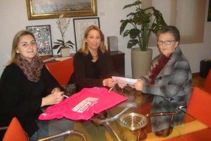 La alcaldesa, Águeda Reynés, y la concejala Analía Noval, entregando la mitad de lo recaudado a Lola Mir, presidenta de ALBA - Aj. Maó