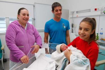 En brazos de Erika. La mayor de la familia Carreras Sosa, de diez años de edad, quiso coger a su nueva hermana. Mientras, sus padres las miraban orgullosos - Gemma Andreu