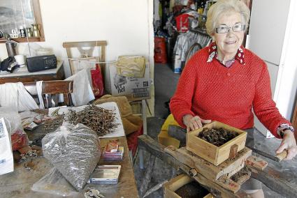 Marianela Socías està acabant de picar el tabac que va cultivar el seu home. Ho fa a una cotxeria que hi ha a prop de casa seva, a Sant Climent.