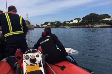 Los bomberos de Ciutadella, en plena operación de traslado del delfín muerto.