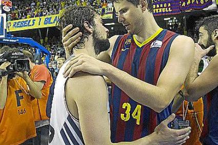 El ala-pívot esloveno del FC Barcelona, Bostjan Nachbar (d), consuela al base del Real Madrid Sergio Llull (i), tras proclamarse campeones de la ACB después de vencer al equipo blanco en el cuarto partido de la final de la Liga Endesa que se ha disputado esta tarde en el Palau Blaugrana, en Barcelona.