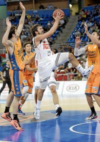 El base español del Real Madrid Sergio Llull (c) entra a canasta ante los jugadores del Valencia Basket Guillem Vives (i) y Pablo Aguilar (d), en la primera semifinal de la Supercopa de Baloncesto.