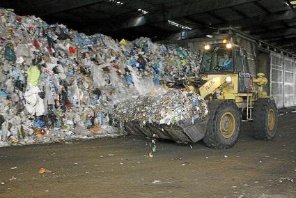 Una máquina transporta los residuos para ser compactados y almacenados en el interior de una nave en las instalaciones de Milà. El vertedero lleva clausurado desde el pasado 23 de diciembre, cuando la Comisión balear de Medio Ambiente ordenó paralizar los vertidos por las filtraciones