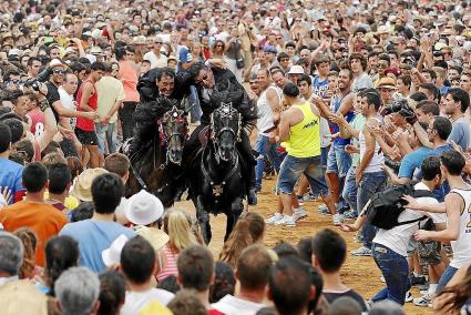 Un joven con una mochila a la espalda se aparta a tiempo al paso de los caballos, en los Jocs matinales del año pasado