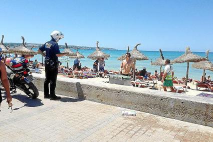 PALMA. TURISMO. TURISTAS EN LA PLATJA DE PALMA. AGENTE DE LA POLICIA LOCAL