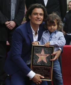 Actor Orlando Bloom of Britain stands with his son Flynn before receiving a star on the Hollywood Walk of Fame in Hollywood, Los