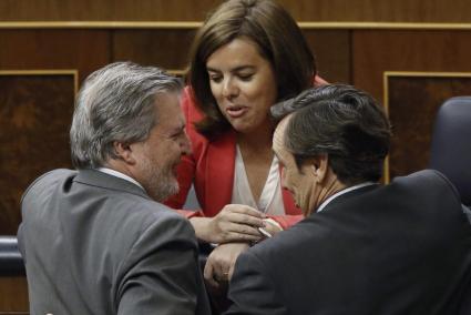 La vicepresidenta del Gobierno, Soraya Sáenz de Santamaría, conversa con el ministro de Educación, Íñigo Méndez de Vigo (i), y el portavoz del PP en el Congreso, Rafael Hernando, poco antes de que comenzara la sesión de control al Gobierno en la Cámara Baja