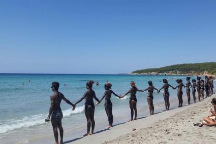 Los activistas, teñidos de negro, han formado una cadena humana frente al mar