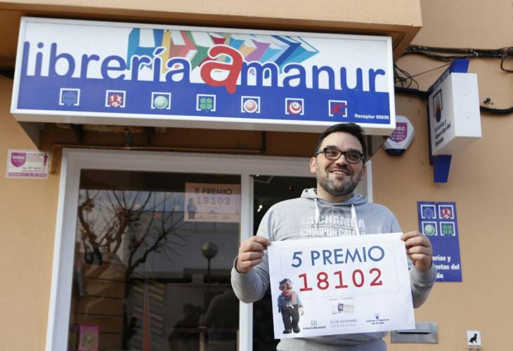 Manuel Jesús Sánchez, de la Librería Amanur de Ciutadella, sostiene el cartel con el número premiado