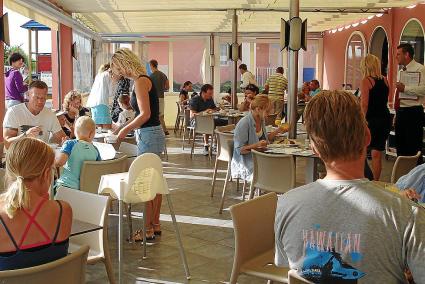 Los turistas desayunan en la terraza de un hotel durante el verano