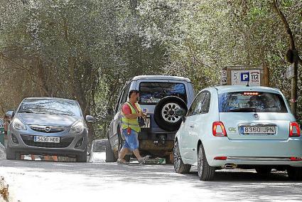 Circulación ante la entrada del parking privado de Macarella, unos 750 metros antes del aparcamiento público .