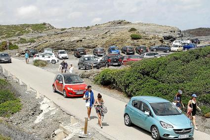 Coches aparcados en los arcenes de la estrecha carretera costera.