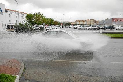 Un coche atraviesa un charco producido por las lluvias del fin de semana