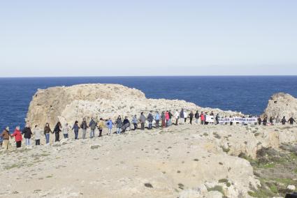 Unas 150 personas han formado una larga cadena humana sobre el acantilado, a los pies de la antigua torre de defensa de Fornells