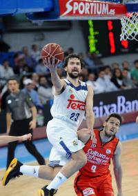 El base menorquín del Real Madrid Sergio Llull entra a canasta ante el base belga del Valencia Basket, Sam Van Rossom, en la fin