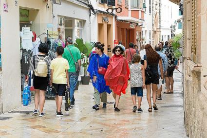 Los turistas tuvieron que recurrir a los chubasqueros para pasearse por el centro de Ciutadella