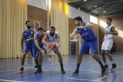 Biel Torres (dorsal 9) observa la lucha por el balón entre Miquel Nadal y su nuevo compañero Jan Orfil