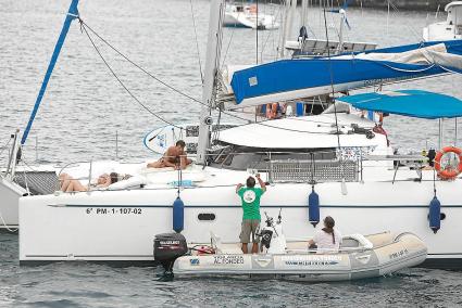 Los dueños de un buque de recreo fondeado en el puerto de Ciutadella reciben un folleto informativo