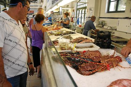 Los clientes observan las langostas de Menorca este martes en la Pescateria de Maó