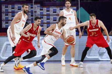 El capitán de la selección española de baloncesto Juan Carlos Navarro (c) intenta avanzar con el balón ante la oposición del bas