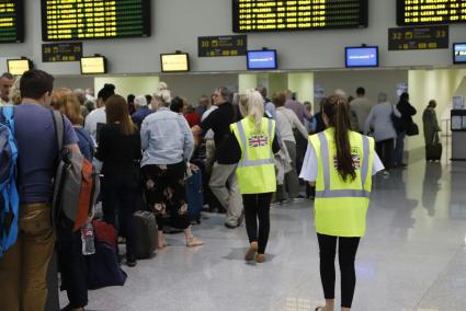 Colas de pasajeros este lunes en el mostrador de Monarch del aeropuerto de Menorca.