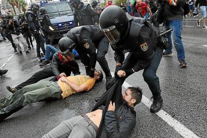 Agentes de Policía inmovilizan a participantes en el referéndum