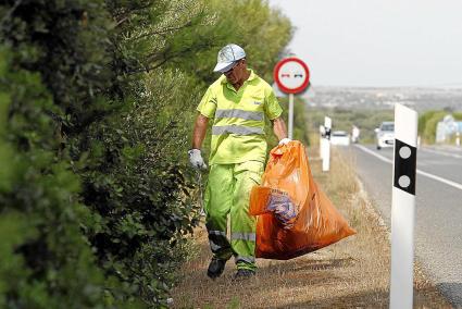 Uno de los operarios de la empresa haciendo labores de limpieza de las cunetas de la carretera Me-1.