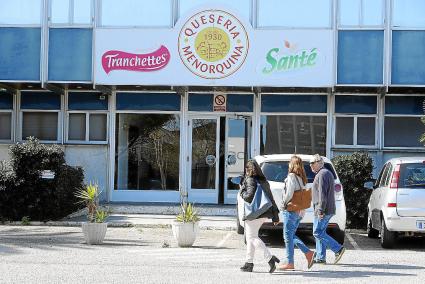 Un grupo de trabajadores frente a la entrada principal de la fábrica de Quesería Menorquina