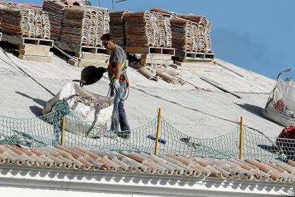 Dos trabajadores de una constructora local durante unas obras de sustitución de cubiertas, en una imagen de archivo.