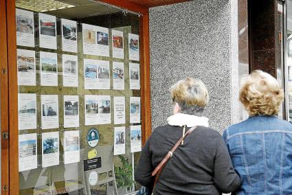 Imagen de archivo de dos mujeres observando las ofertas disponibles en una inmobiliaria