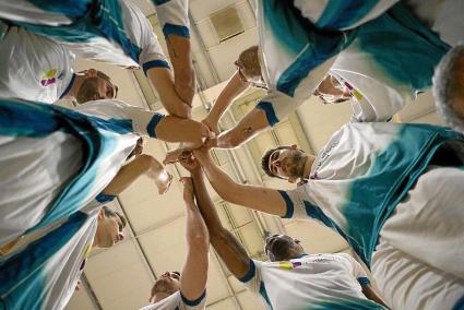 Los jugadores del equipo insular, en un plano contrapicado, unen las manos antes de empezar un partido