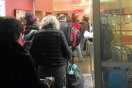 Pasajeros del vuelo cancelado Valencia-Barcelona hacen cola en la recepción de un hotel de Santa Coloma para pasar la noche.