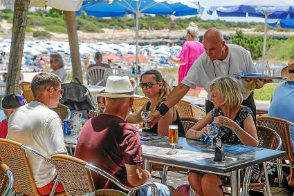 Un camarero sirve una mesa en una zona turística de Ciutadella