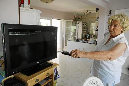 La presidenta de la asociación de vecinos, Gabriela García, en su casa frente el televisor